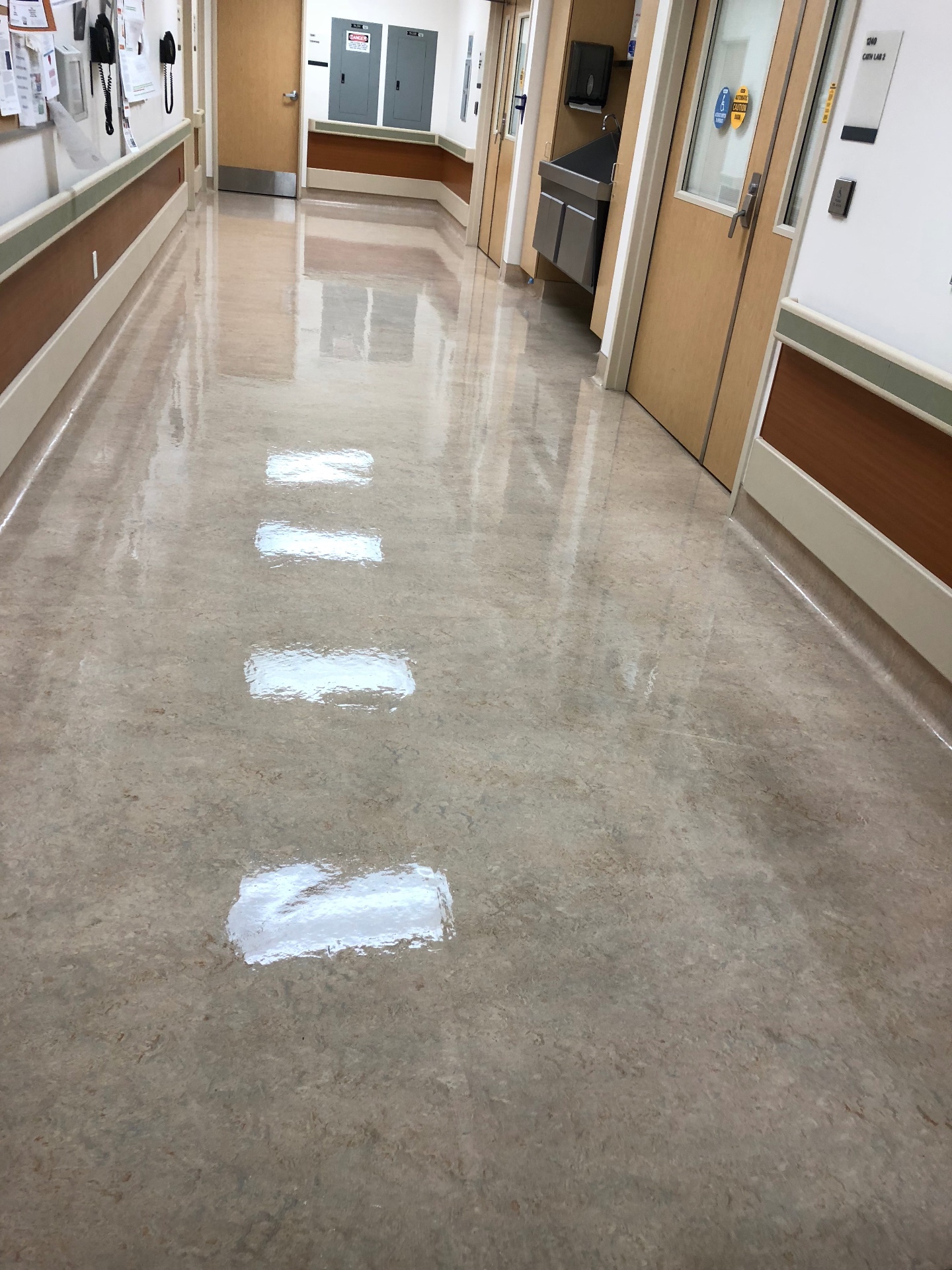 Commercial floor stripping in progress at a medical facility hallway